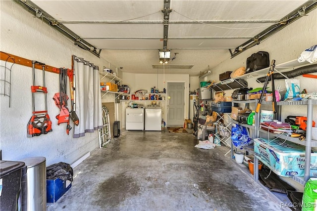 garage featuring a garage door opener, a textured wall, and separate washer and dryer