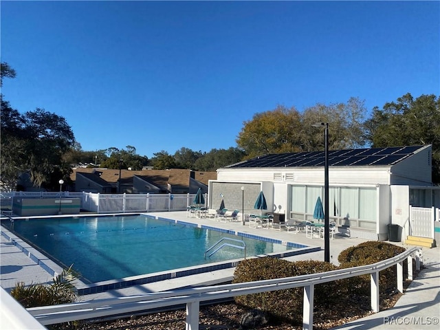 community pool featuring a patio and fence