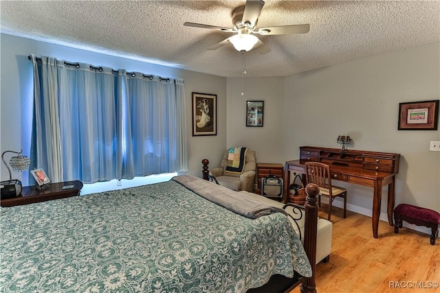 bedroom featuring a textured ceiling, a ceiling fan, and light wood-style floors