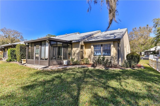 view of front of property with a front lawn, a sunroom, and stucco siding