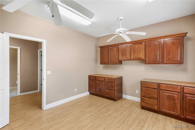 1150 E Cleveland St, Hernando, FL 34442 - kitchen featuring a ceiling fan, a skylight, light wood finished floors, brown cabinetry, and baseboards