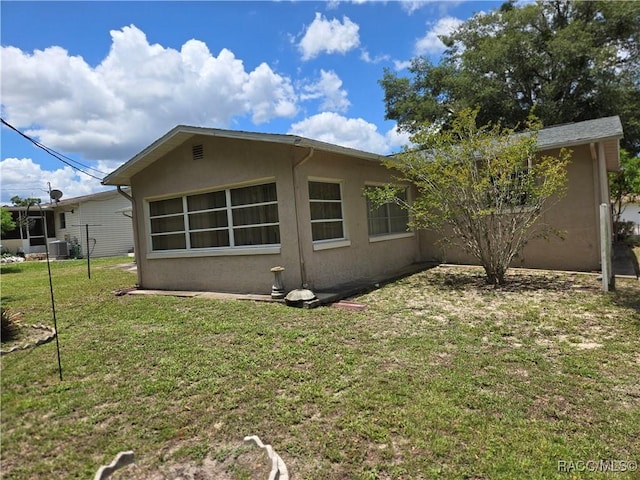215 S Jefferson St, Beverly Hills, FL 34465 - rear view of property with stucco siding and a yard