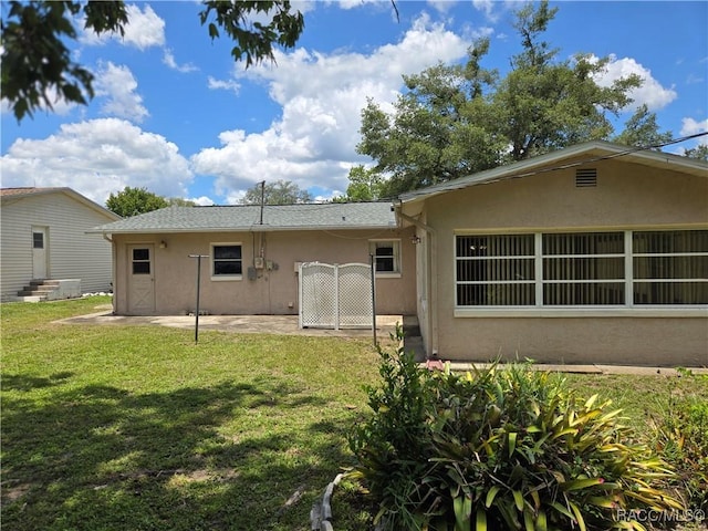 215 S Jefferson St, Beverly Hills, FL 34465 - rear view of property with stucco siding, a lawn, and a patio area