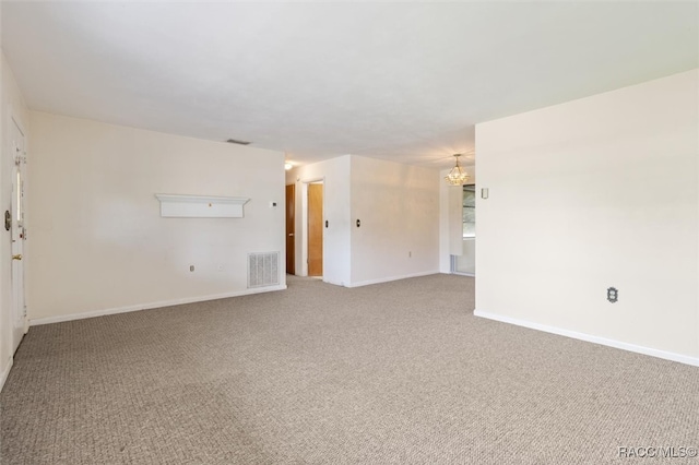 unfurnished room with a notable chandelier and carpet floors