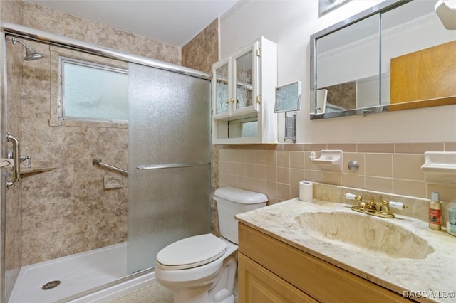 bathroom featuring tasteful backsplash, an enclosed shower, toilet, vanity, and tile walls