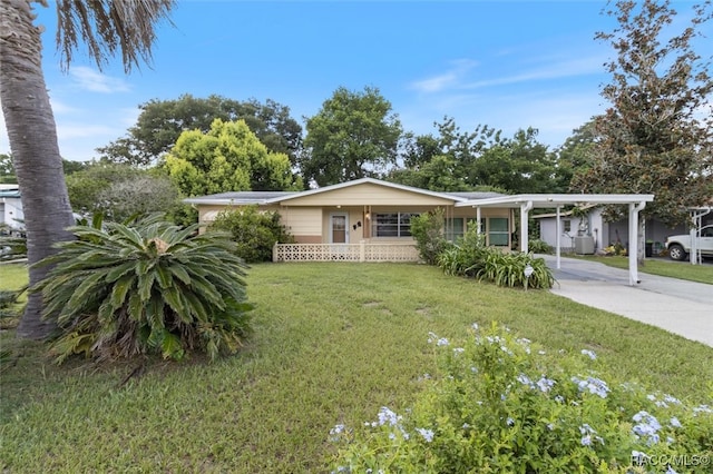 ranch-style house featuring a front lawn, covered porch, and a carport