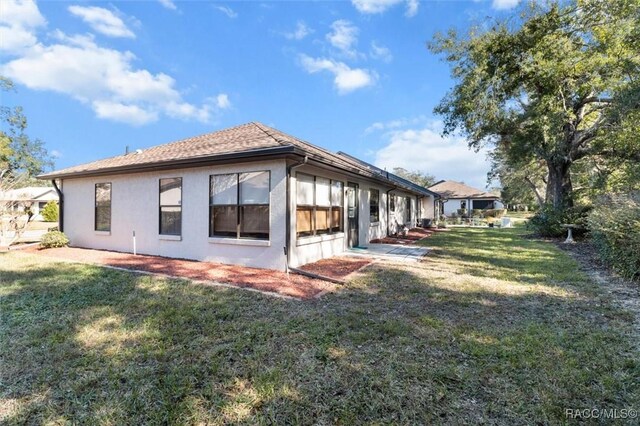 view of side of home with a yard