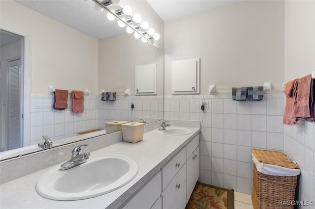 bathroom with tile patterned flooring, vanity, and tile walls