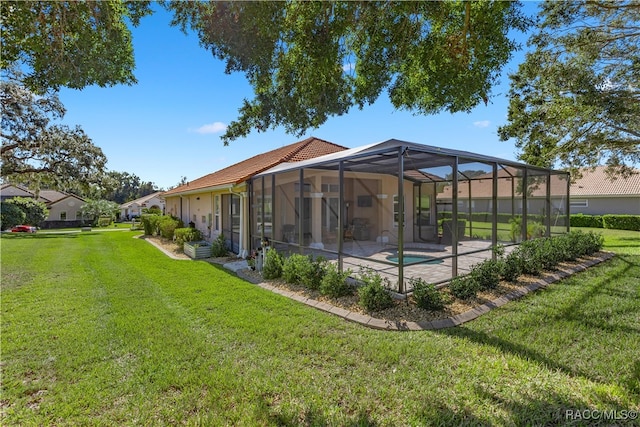 rear view of house with a lawn, a patio area, a lanai, an outdoor pool, and a tiled roof