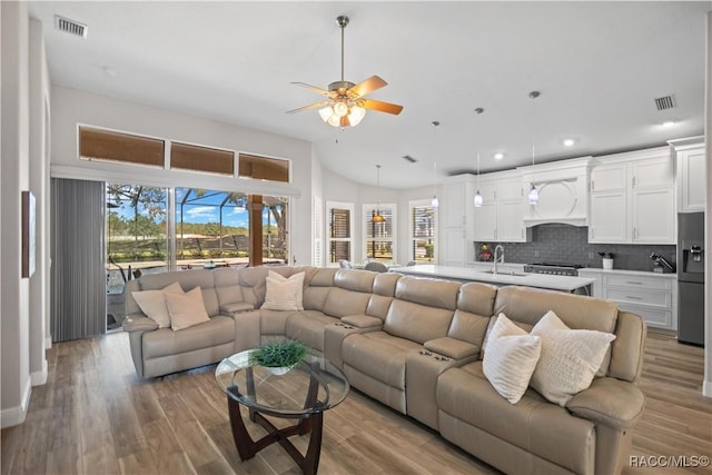 living room with ceiling fan, light wood finished floors, visible vents, and recessed lighting