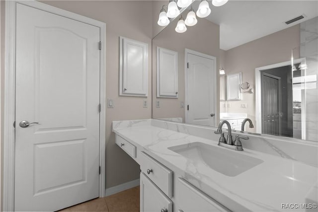 bathroom with a notable chandelier, vanity, visible vents, and tile patterned floors