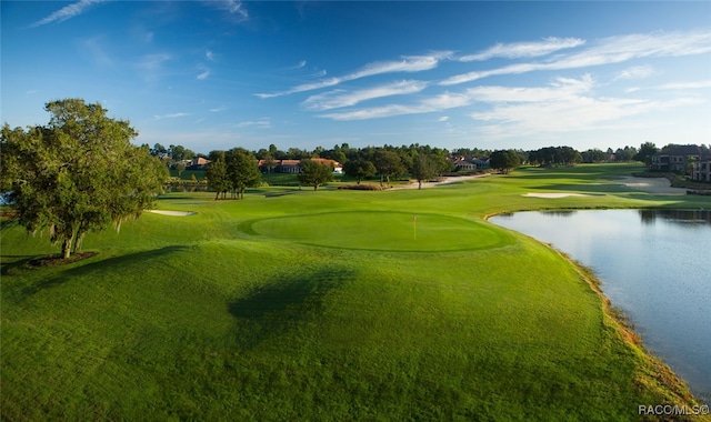 view of community featuring view of golf course, a lawn, and a water view