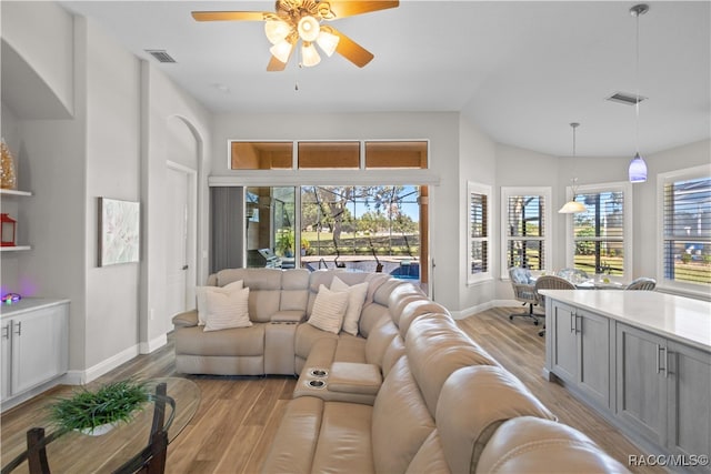 living room featuring visible vents, vaulted ceiling, and light wood-style flooring