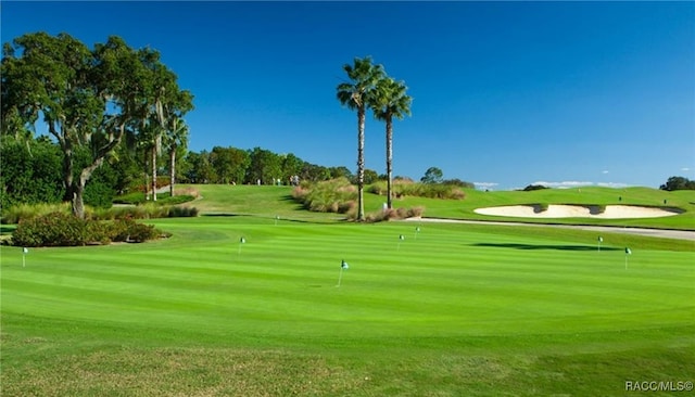 view of property's community featuring golf course view and a lawn