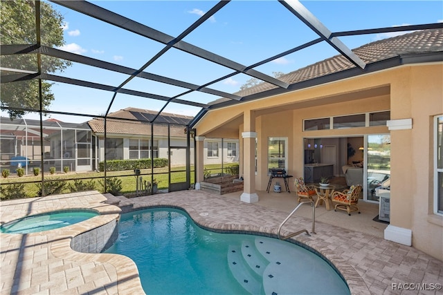 view of pool featuring an in ground hot tub, a lanai, and a patio