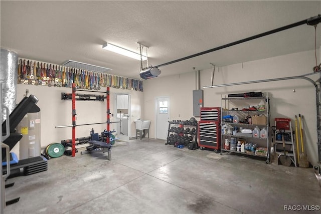 garage with a garage door opener, electric panel, sink, and washer / dryer