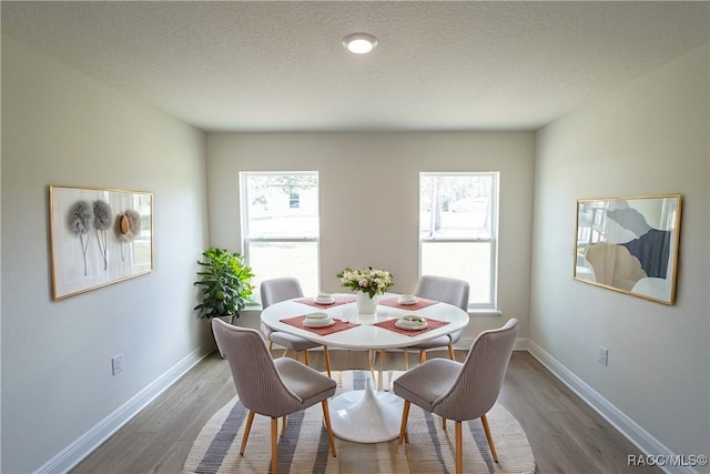 dining room with hardwood / wood-style flooring and a textured ceiling