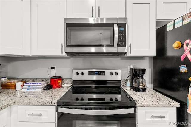 kitchen featuring white cabinets, light stone countertops, and stainless steel appliances