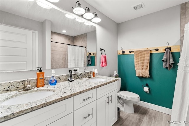 bathroom featuring hardwood / wood-style flooring, a shower with curtain, toilet, and vanity