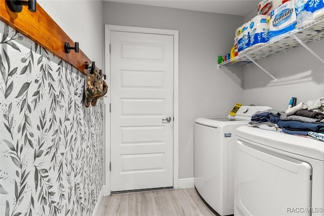 washroom featuring washing machine and clothes dryer and light hardwood / wood-style flooring