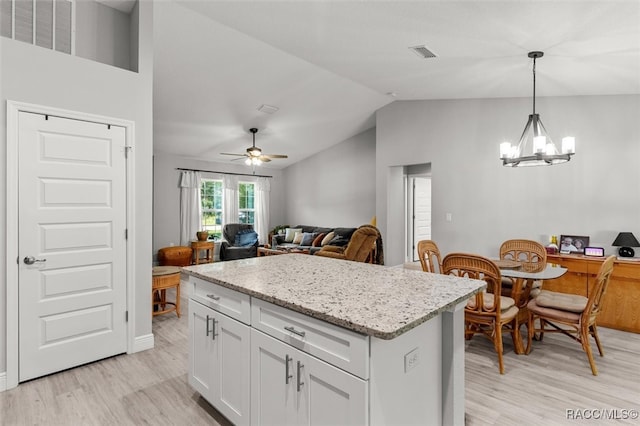 kitchen featuring light wood-type flooring, ceiling fan with notable chandelier, decorative light fixtures, white cabinets, and lofted ceiling