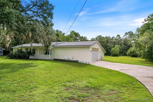 view of front of home featuring a porch, a garage, and a front yard