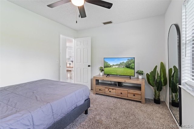 bedroom with ceiling fan, carpet, and a textured ceiling