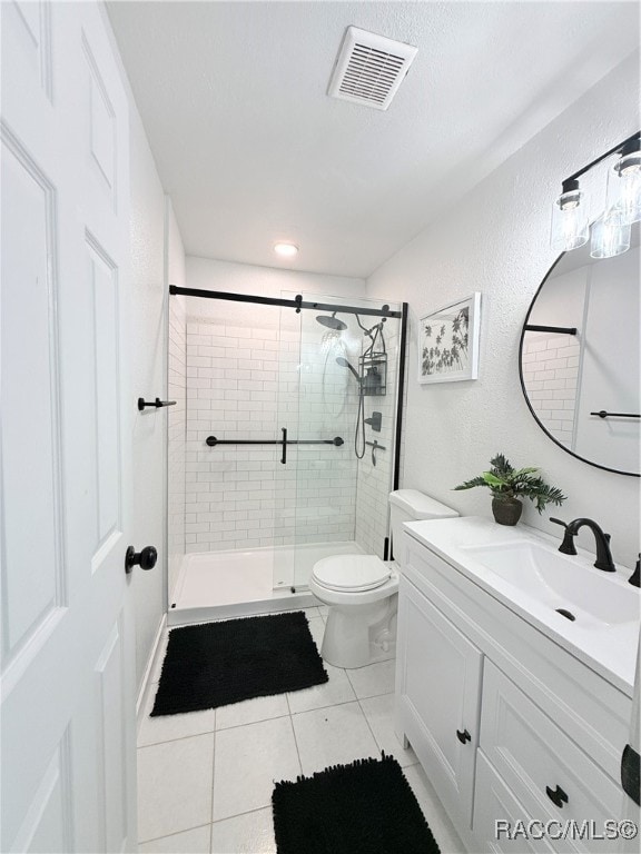 bathroom featuring tile patterned flooring, vanity, an enclosed shower, and toilet