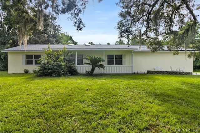 rear view of property featuring a yard