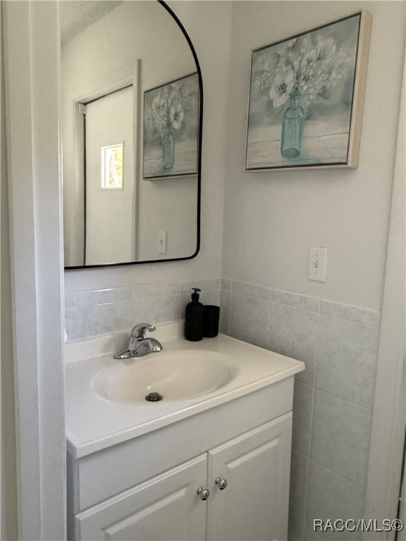 bathroom featuring vanity and tile walls