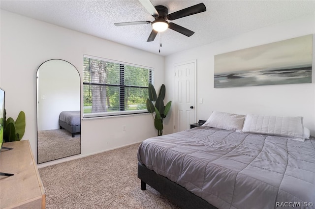 carpeted bedroom with ceiling fan and a textured ceiling