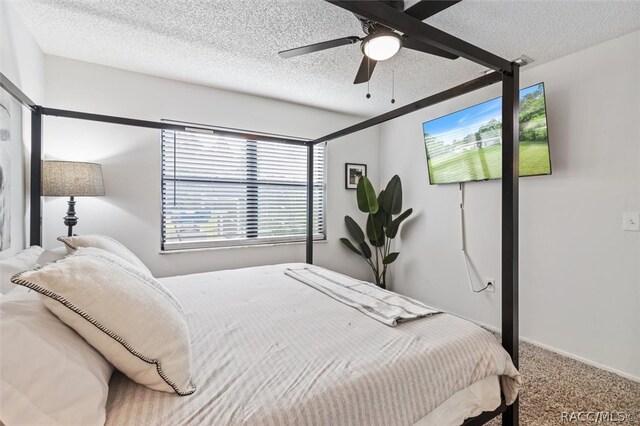 bedroom featuring carpet, a textured ceiling, and ceiling fan