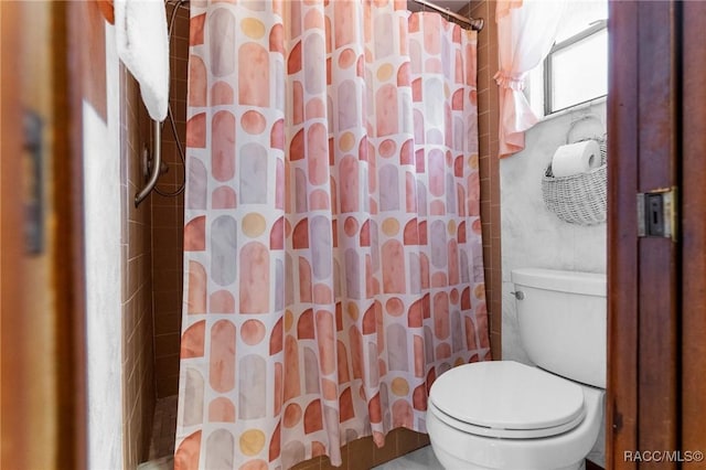bathroom with a shower with curtain and toilet