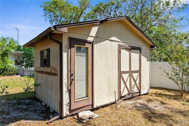 view of shed featuring fence