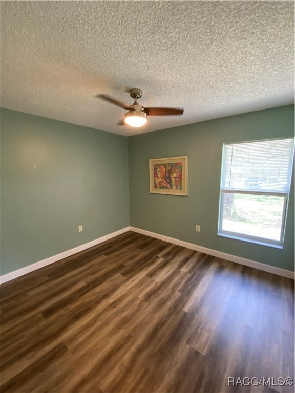 empty room featuring a textured ceiling, dark hardwood / wood-style flooring, and ceiling fan