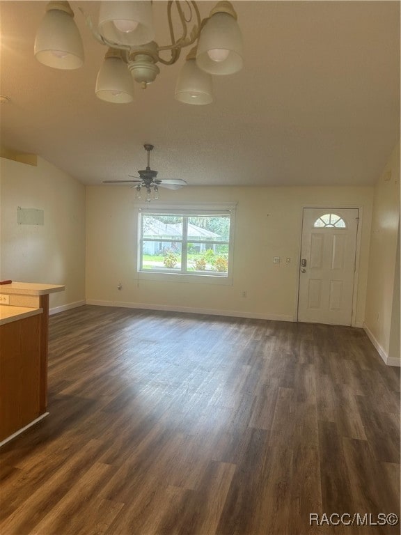 unfurnished living room with ceiling fan, dark wood-type flooring, and vaulted ceiling