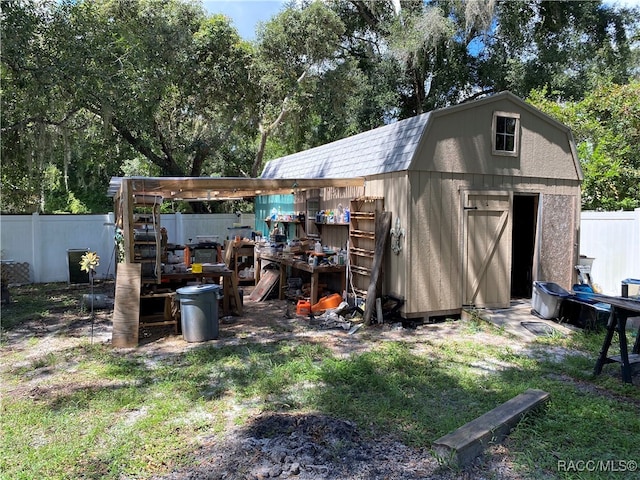 rear view of property with a lawn and a shed