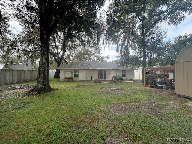 back of property with a storage unit and a lawn