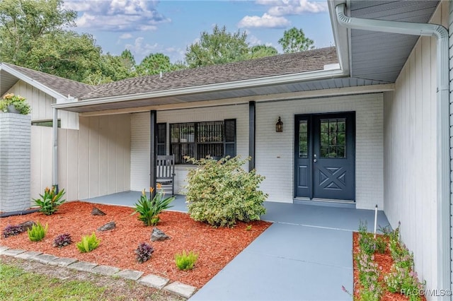 4 Chinkapin Ct, Homosassa, FL 34446 - view of exterior entry featuring covered porch, brick siding, and roof with shingles