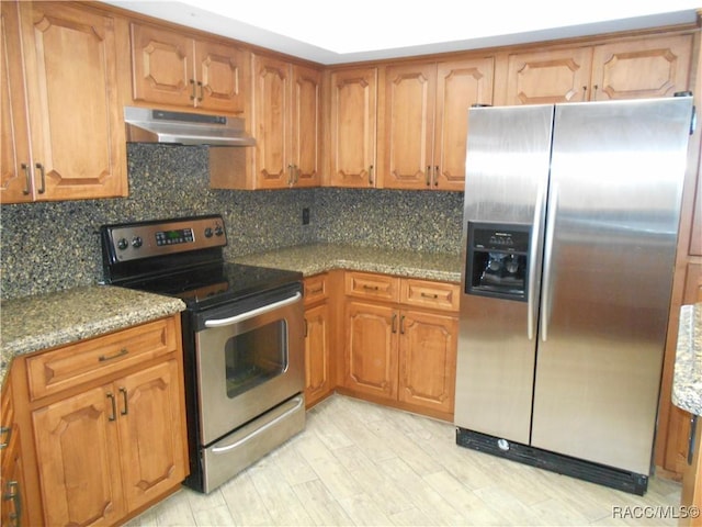 4 Chinkapin Ct, Homosassa, FL 34446 - kitchen featuring brown cabinets, tasteful backsplash, under cabinet range hood, and stainless steel appliances