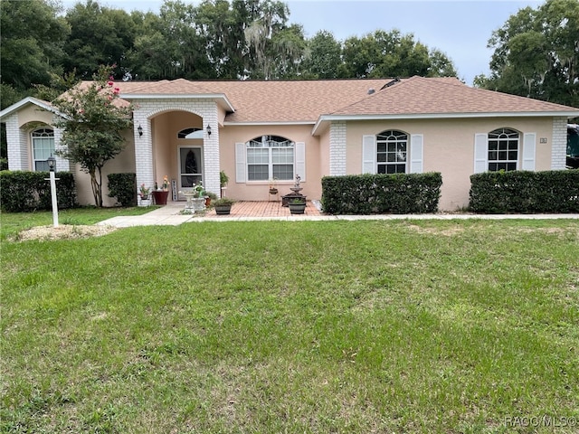 single story home featuring a front lawn