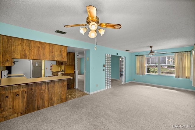 522 Hiawatha Ave, Inverness, FL 34452 - kitchen with ceiling fan, light colored carpet, brown cabinets, a textured ceiling, and baseboards