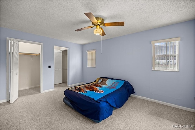 522 Hiawatha Ave, Inverness, FL 34452 - carpeted bedroom with multiple windows, two closets, a textured ceiling, a ceiling fan, and baseboards