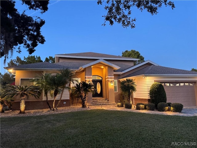 view of front of house with a yard and a garage