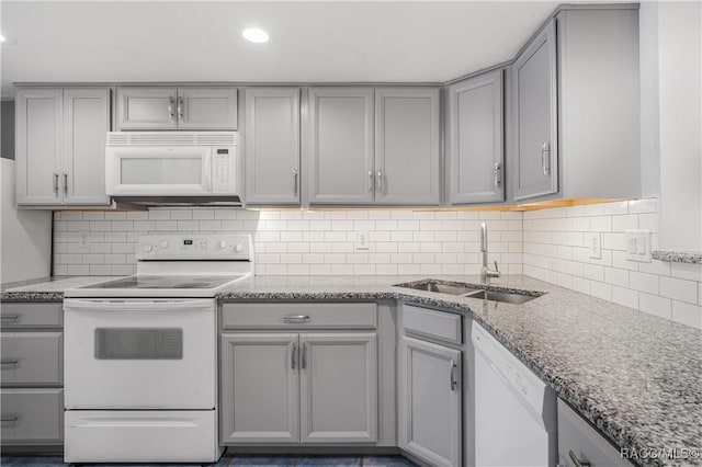 kitchen with gray cabinetry, decorative backsplash, sink, and white appliances