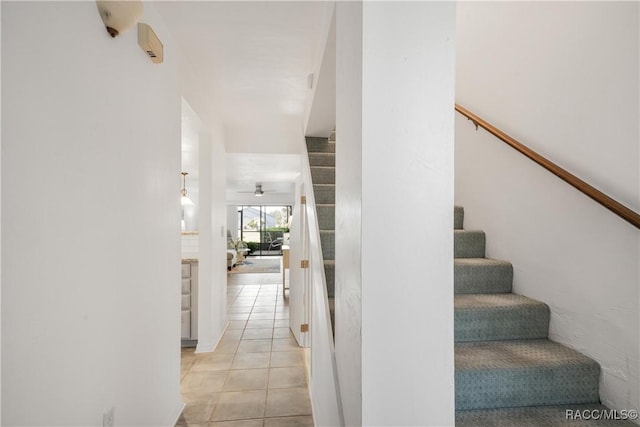 stairway featuring tile patterned floors and ceiling fan