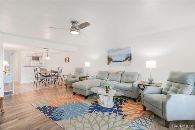 living room with ceiling fan and light hardwood / wood-style flooring