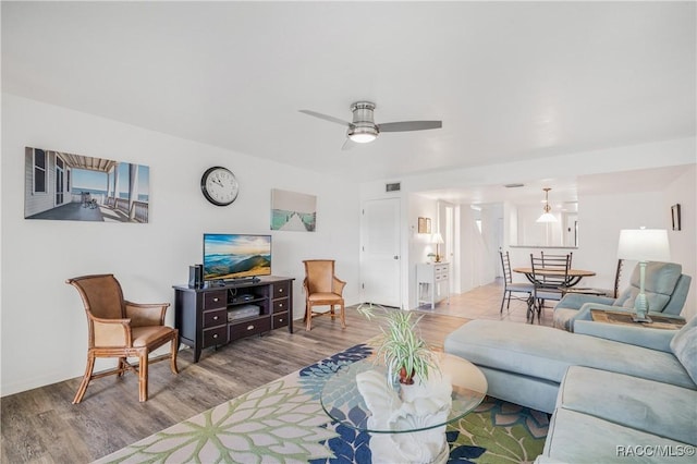 living room featuring ceiling fan and light hardwood / wood-style flooring