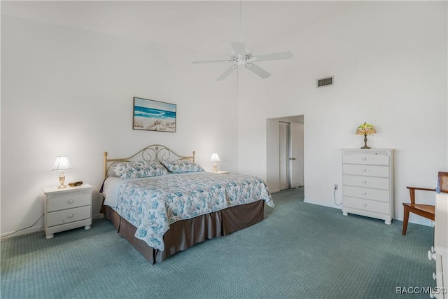 carpeted bedroom with ceiling fan and a towering ceiling