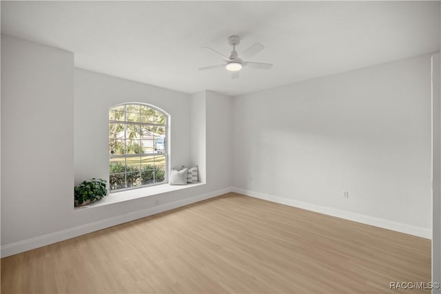 empty room with ceiling fan and light hardwood / wood-style floors